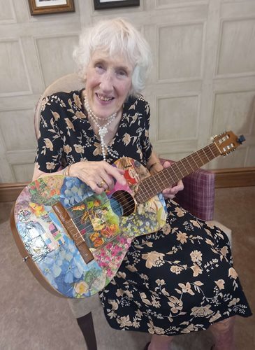 Team members at Ancasta Grove helped Cathy learn to the play the guitar at the age of 87. 