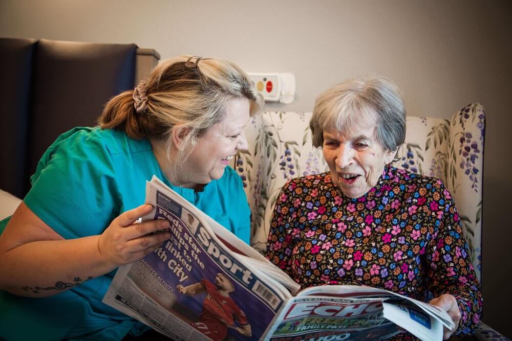 Team Leader Care - Llys Herbert reading with a resident